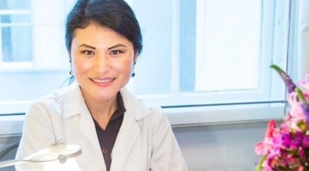 Professional clinician at WE Clinic London, London, England, GB beside a floral arrangement.