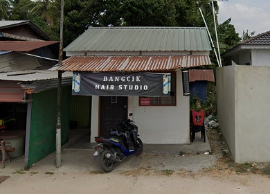 Street view of Bangcik Barber Shop in BUKIT MERTAJAM, Pulau Pinang, MY with a rustic facade and motorcycle.