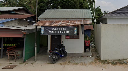 Street view of Bangcik Barber Shop in BUKIT MERTAJAM, Pulau Pinang, MY with a rustic facade and motorcycle.