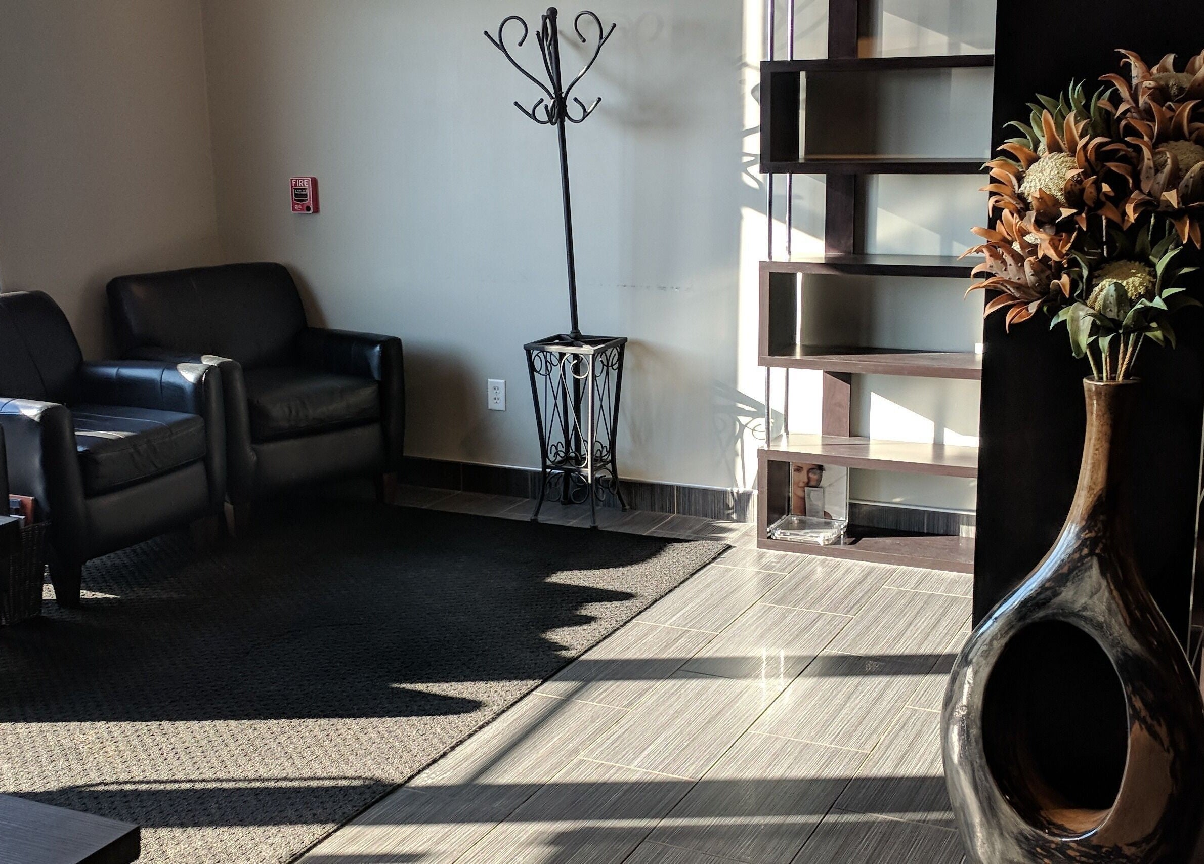 Chic lounge with leather chairs at J. Cole Salon & Spa, Saylor Township, Iowa, US. Sunlit, modern decor.
