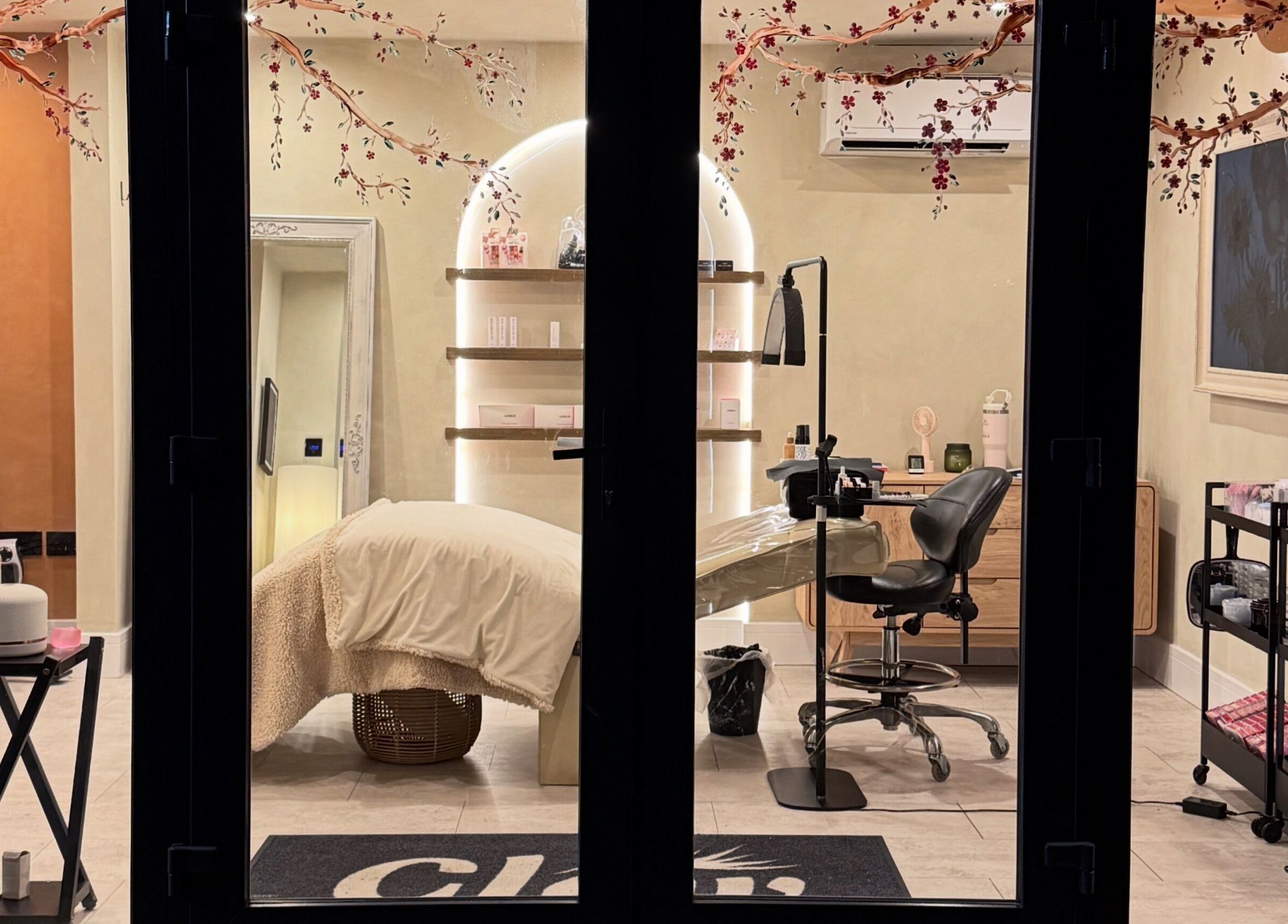 Interior view of soothing treatment room at Glow By Clo, Aldershot, England, GB with cozy chair and decor.
