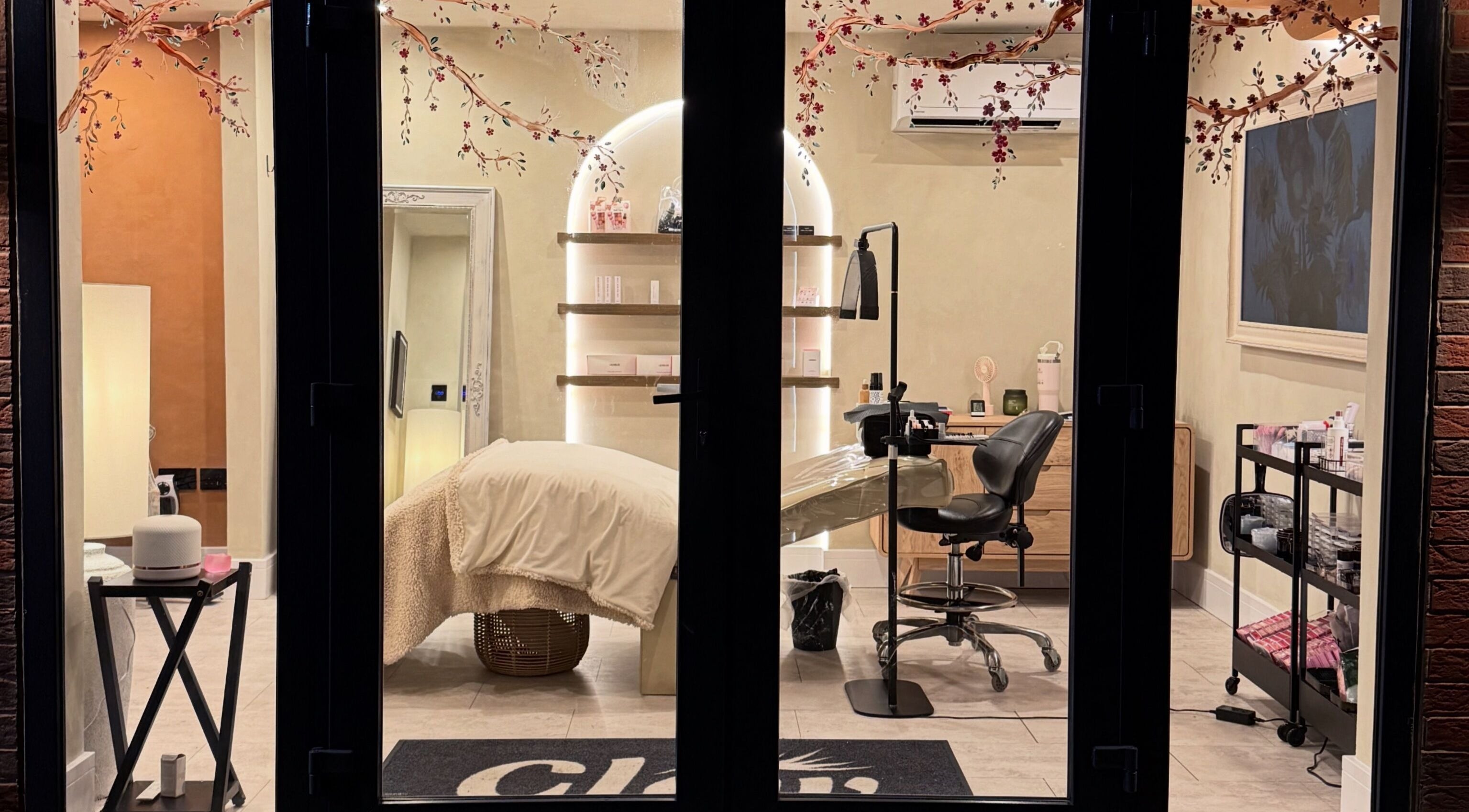 Interior view of soothing treatment room at Glow By Clo, Aldershot, England, GB with cozy chair and decor.