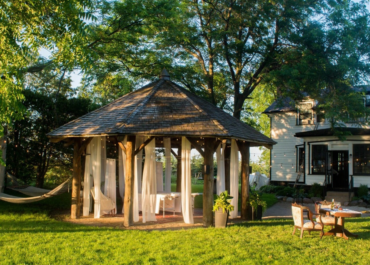 Gazebo and chairs at Harvest Spa Stevenson Inn and Spa, Ontario, Ontario, CA amidst lush greenery.