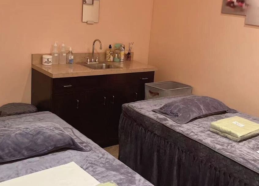 Relaxing massage room at Red Sun Spa in Naperville, Illinois, US, featuring cozy treatment beds and calming decor.