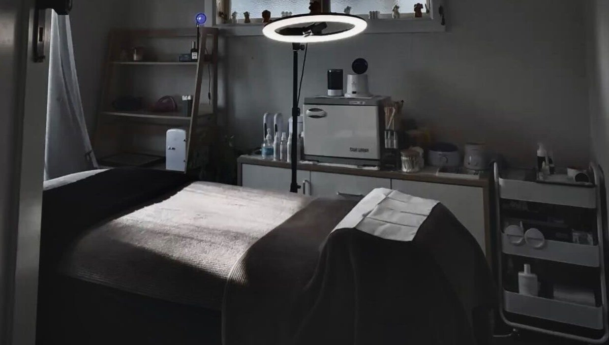 A tranquil treatment room at 09 Brows in Auckland, Auckland, NZ, featuring a massage bed and ambient lighting.