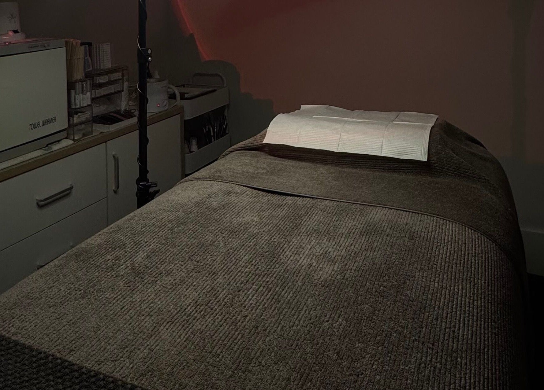 Tranquil treatment room at 09 Brows, Auckland, NZ, featuring a comfortable massage table for wellness services.