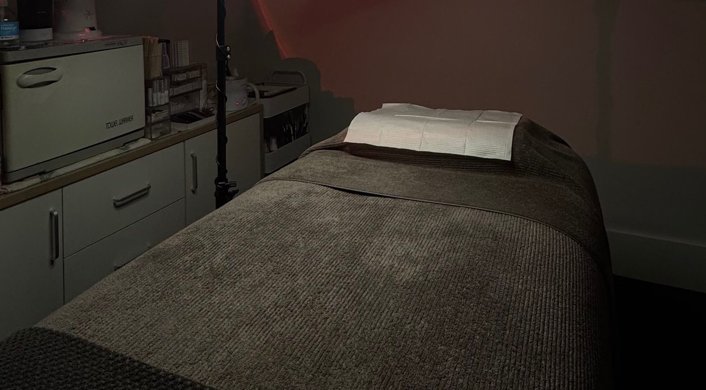 Tranquil treatment room at 09 Brows, Auckland, NZ, featuring a comfortable massage table for wellness services.