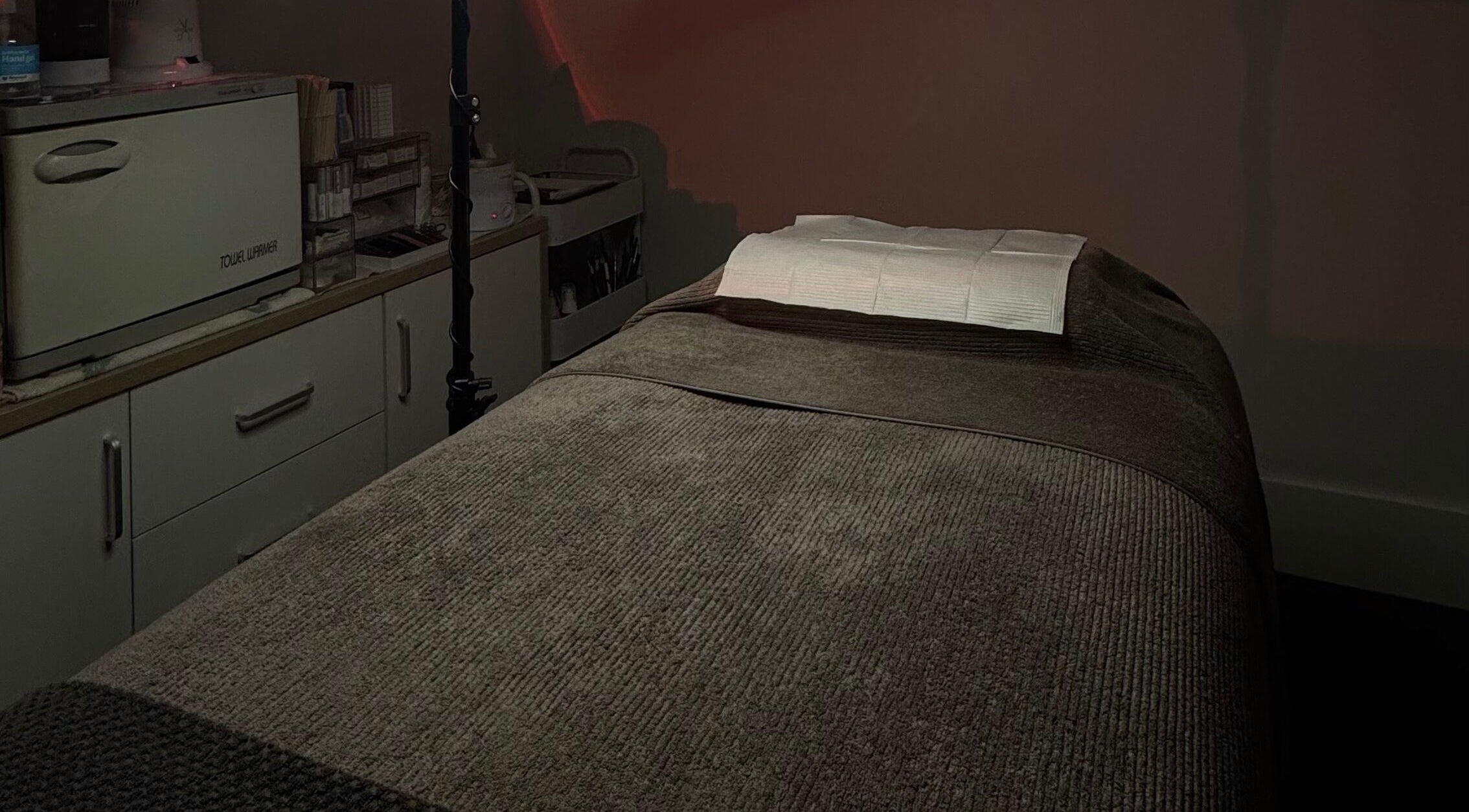 Tranquil treatment room at 09 Brows, Auckland, NZ, featuring a comfortable massage table for wellness services.