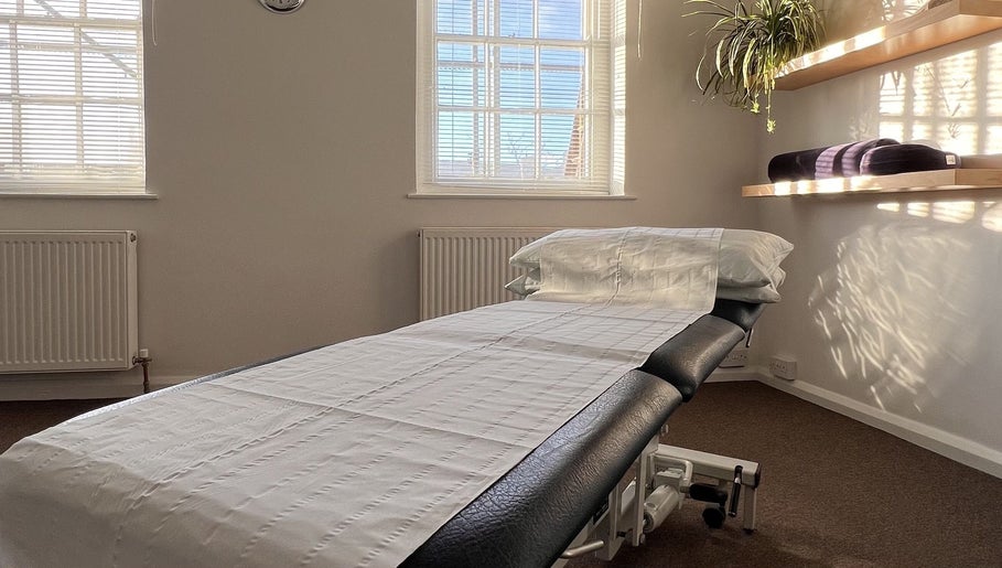 Cozy treatment room at The Green Parrot Clinic, Swaffham, England, GB with sunlit windows and soft linens.