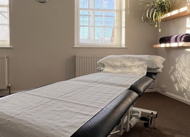 Cozy treatment room at The Green Parrot Clinic, Swaffham, England, GB with sunlit windows and soft linens.