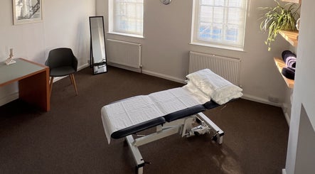 Calming treatment room in The Green Parrot Clinic, Swaffham, England, GB, featuring a therapy bed and elegant decor.