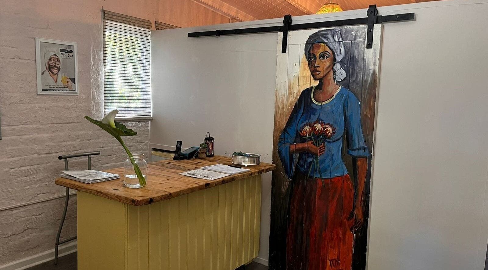 Reception desk at Mist Spa, Misty Mountain Reserve with vibrant art, Garden Route, Eastern Cape, ZA.