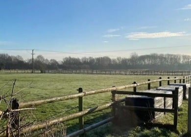 Expansive green fields near Sweet Escapes Beauty & Wellbeing in Rolleston-on-dove, England, GB under a clear blue sky.