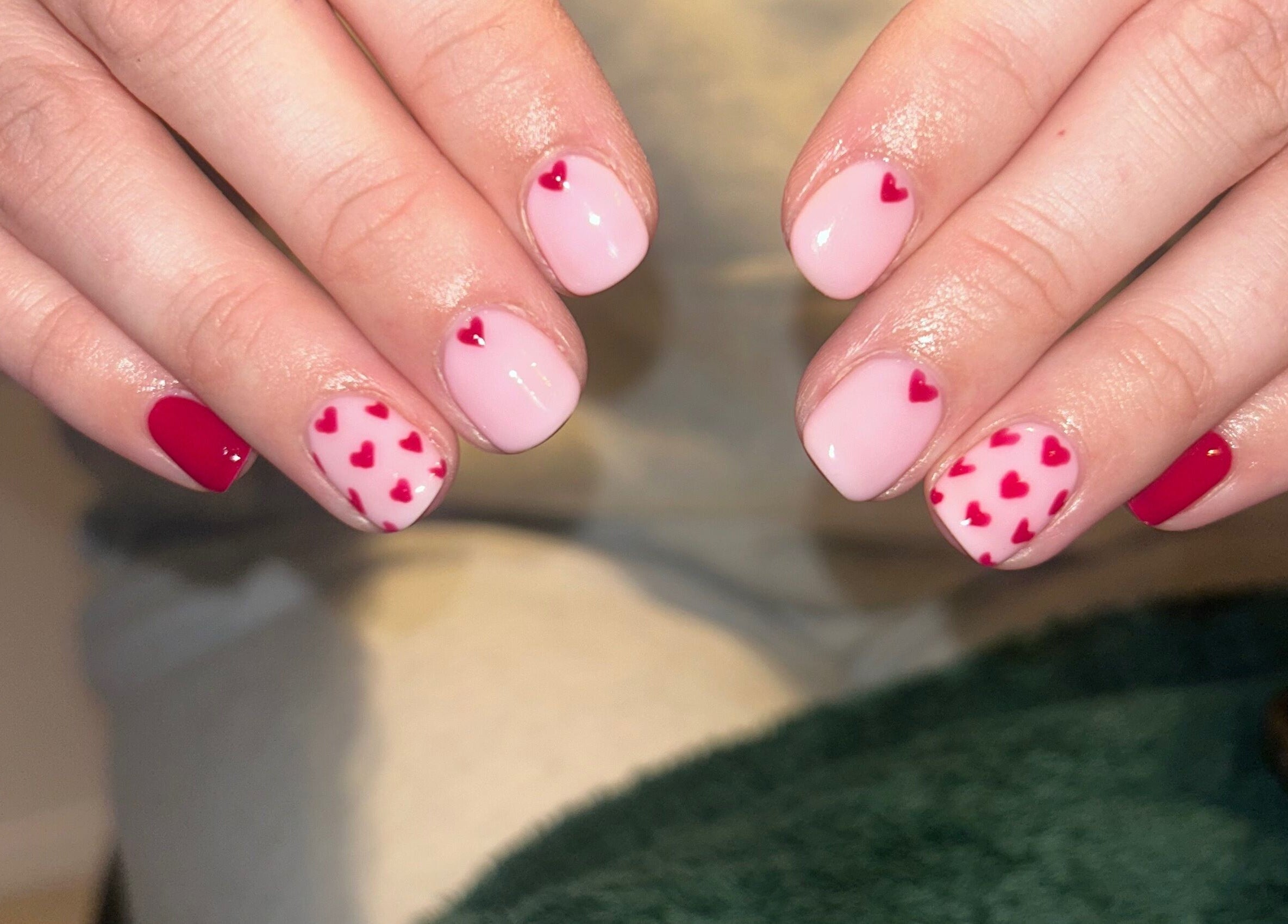 Heart-themed manicure at Hollie’s Beauty in Redbourn, England, GB, featuring pink and red nail art.