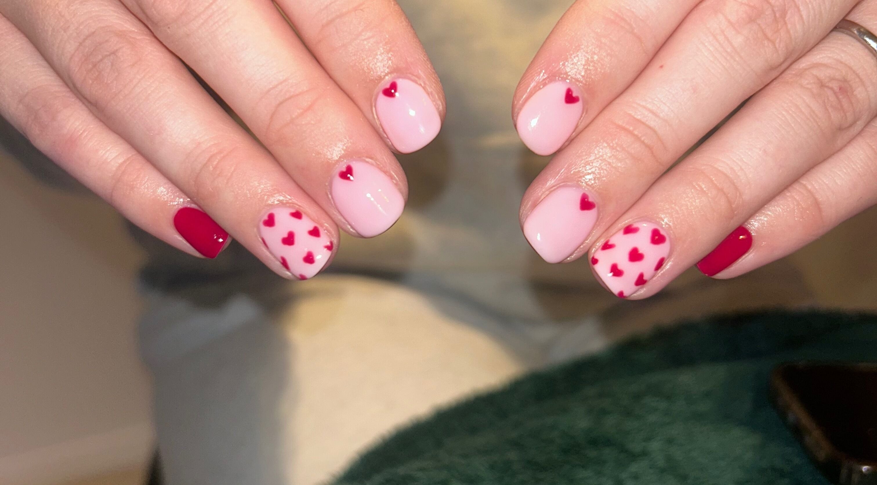 Heart-themed manicure at Hollie’s Beauty in Redbourn, England, GB, featuring pink and red nail art.