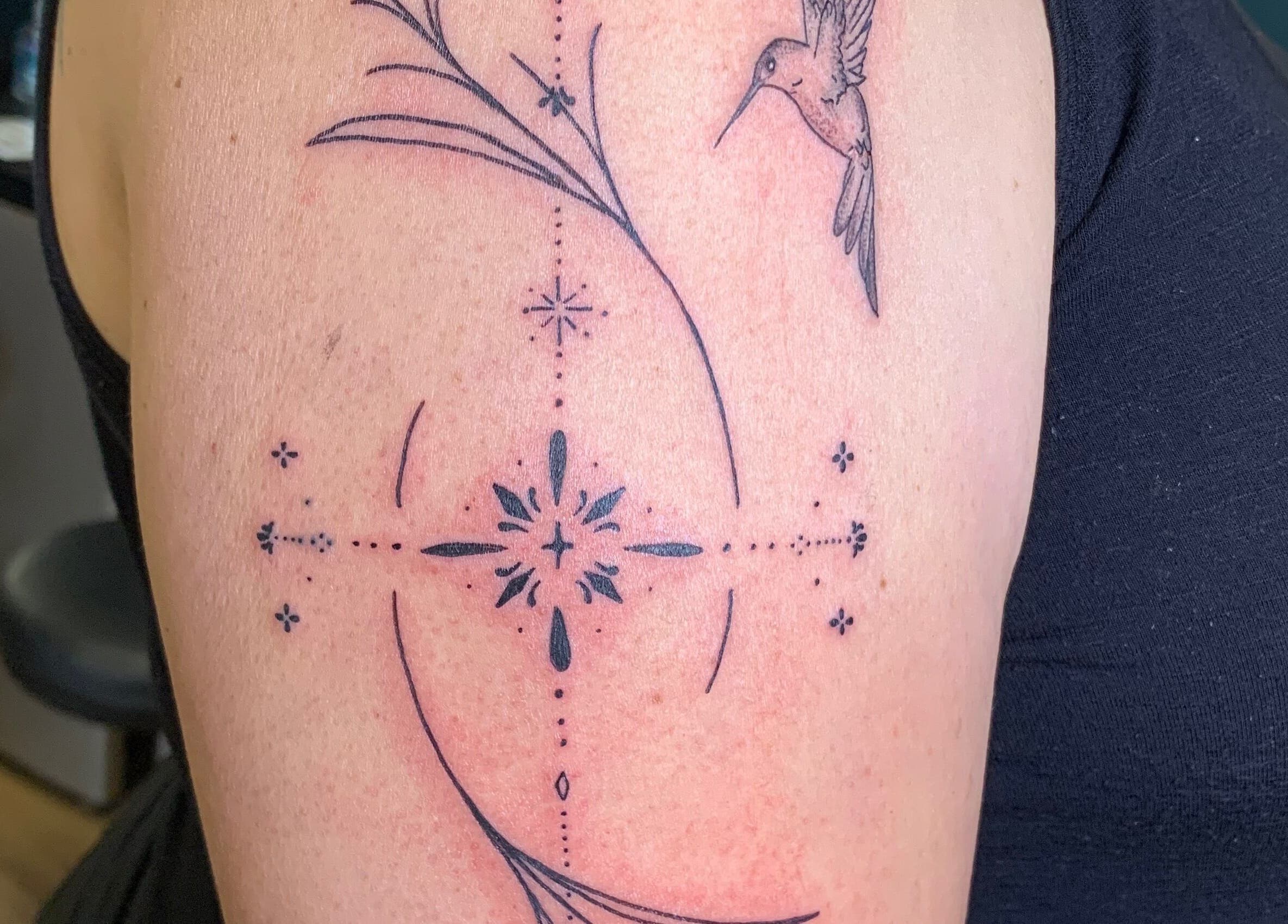 Intricate tattoo design at Ebb and Flow Studio IL, Peru, Illinois, US. Exquisite hummingbird and geometric shapes.