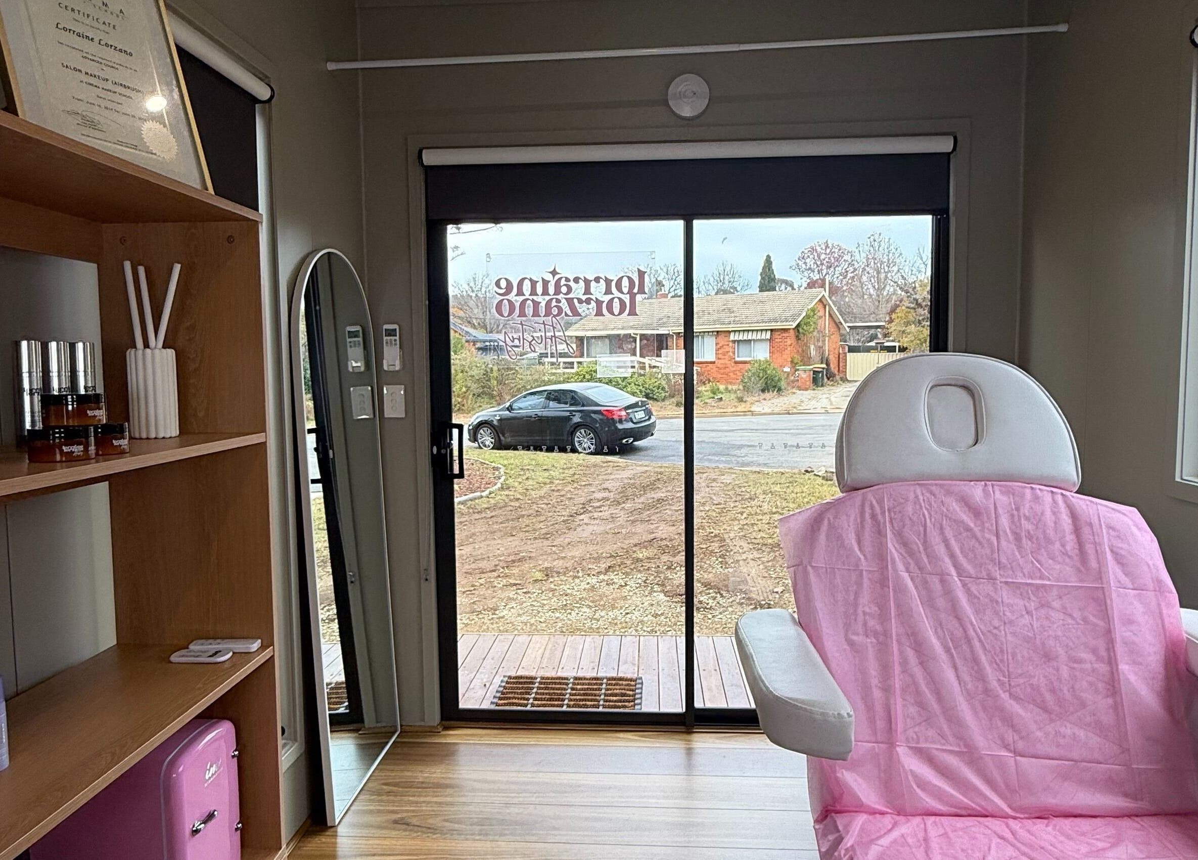 Cozy interior of Lorraine Lorzano Artistry in Downer, ACT, AU showcasing a treatment chair and skincare products.