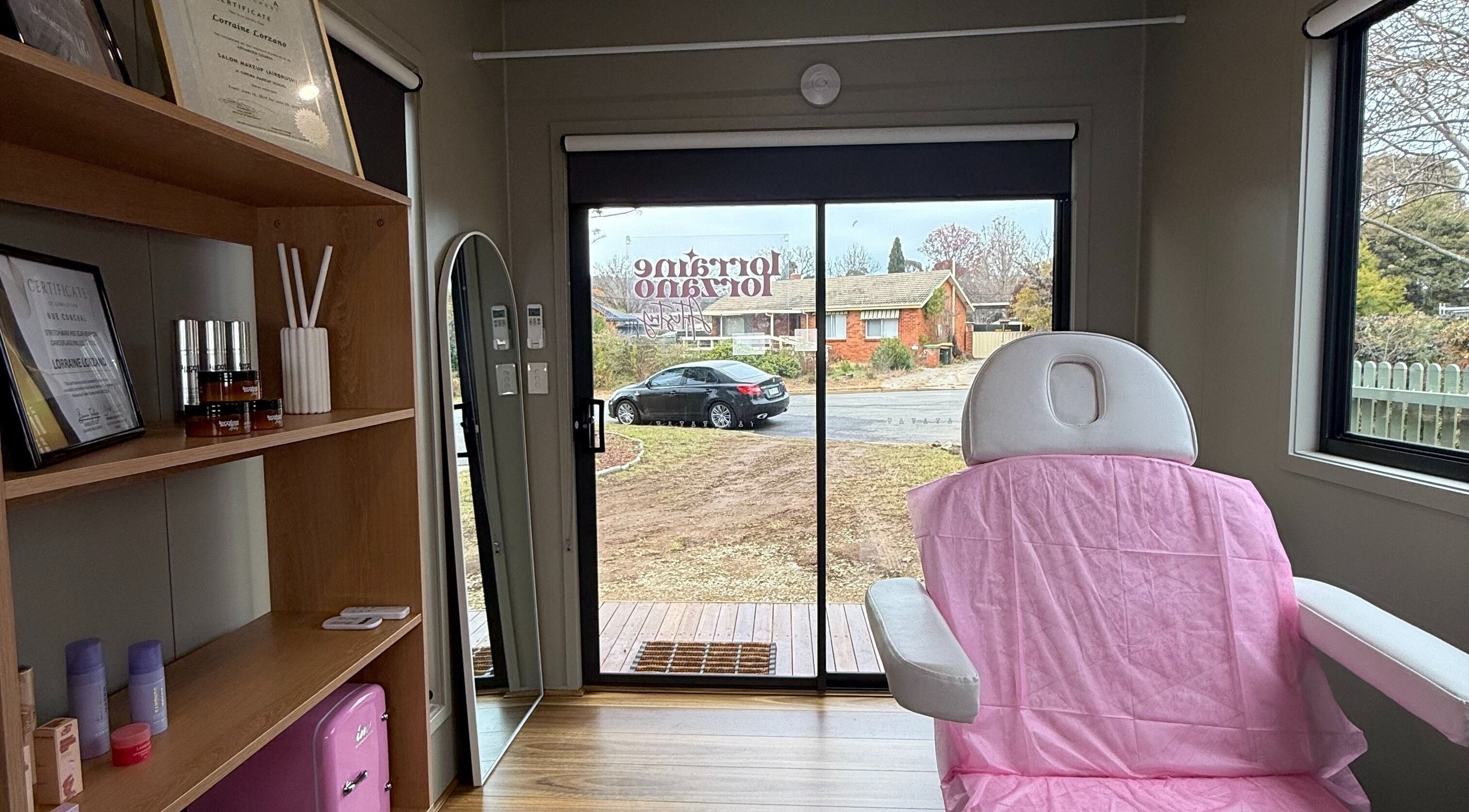 Cozy interior of Lorraine Lorzano Artistry in Downer, ACT, AU showcasing a treatment chair and skincare products.