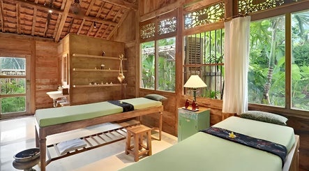 Relaxing spa room at 1919 Spa, Bali, Bali, ID with wooden interior and massage tables overlooking lush greenery.