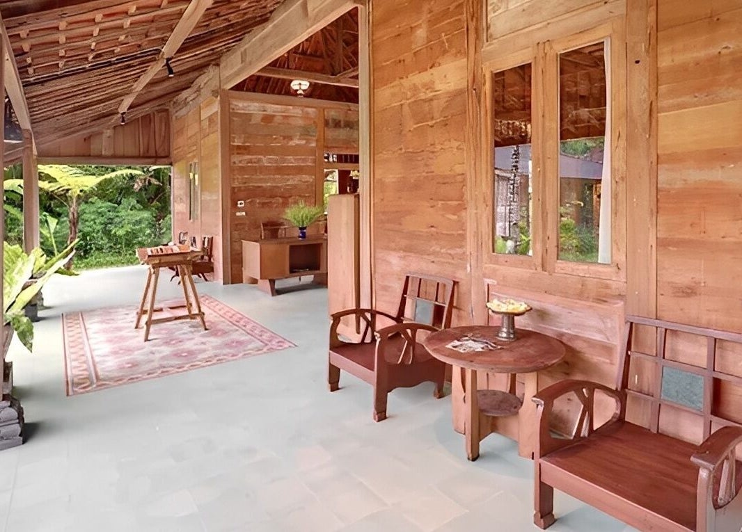 Serene outdoor terrace at 1919 Spa in Bali, Bali, ID, featuring wooden furniture and lush greenery.