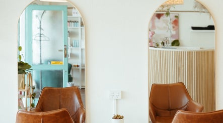 Elegant seating at Aveta Hair and Body in Port Noarlunga, SA, AU with stylish mirrors and decor.