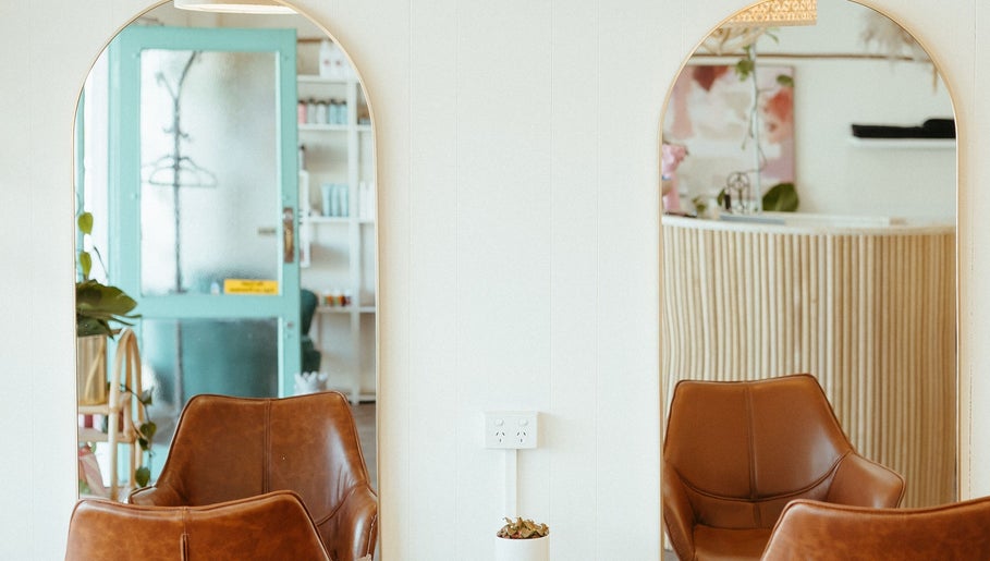 Elegant salon interior with mirrors and seating at Aveta Hair and Body, Port Noarlunga, SA, AU.