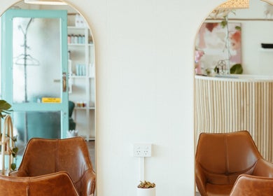 Elegant salon interior with mirrors and seating at Aveta Hair and Body, Port Noarlunga, SA, AU.