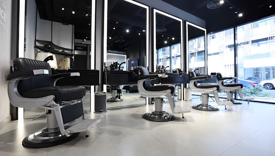 Spacious interior of The Hound DXB barbershop in Dubai with sleek modern styling chairs.