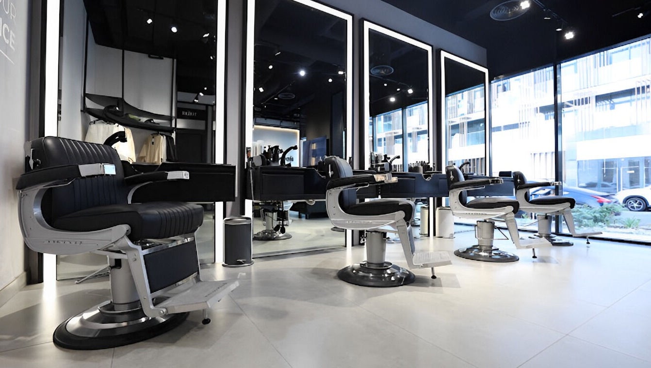 Spacious interior of The Hound DXB barbershop in Dubai with sleek modern styling chairs.