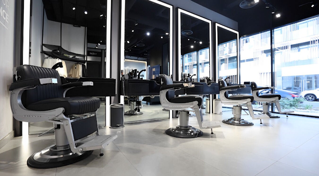 Spacious interior of The Hound DXB barbershop in Dubai with sleek modern styling chairs.