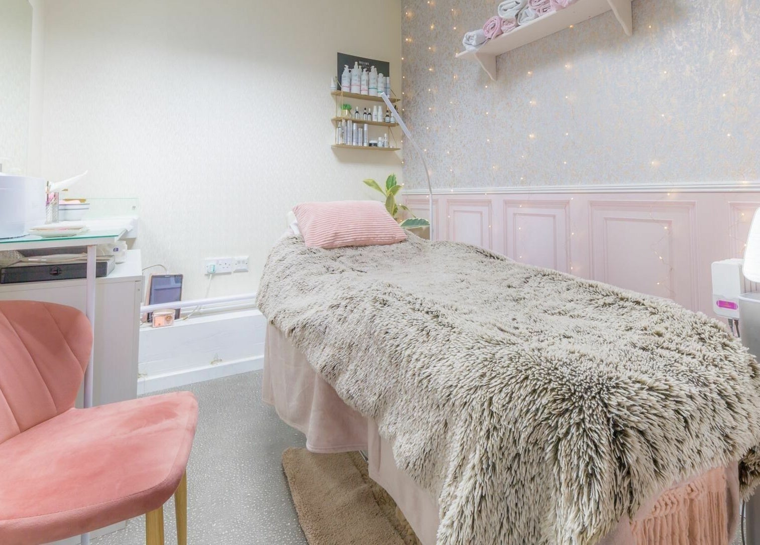 Cozy treatment room at Changing Faces Studio, Exeter, England, GB with plush bedding and soft pink decor.
