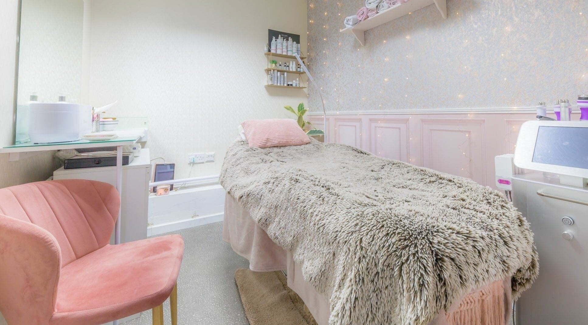 Cozy treatment room at Changing Faces Studio, Exeter, England, GB with plush bedding and soft pink decor.