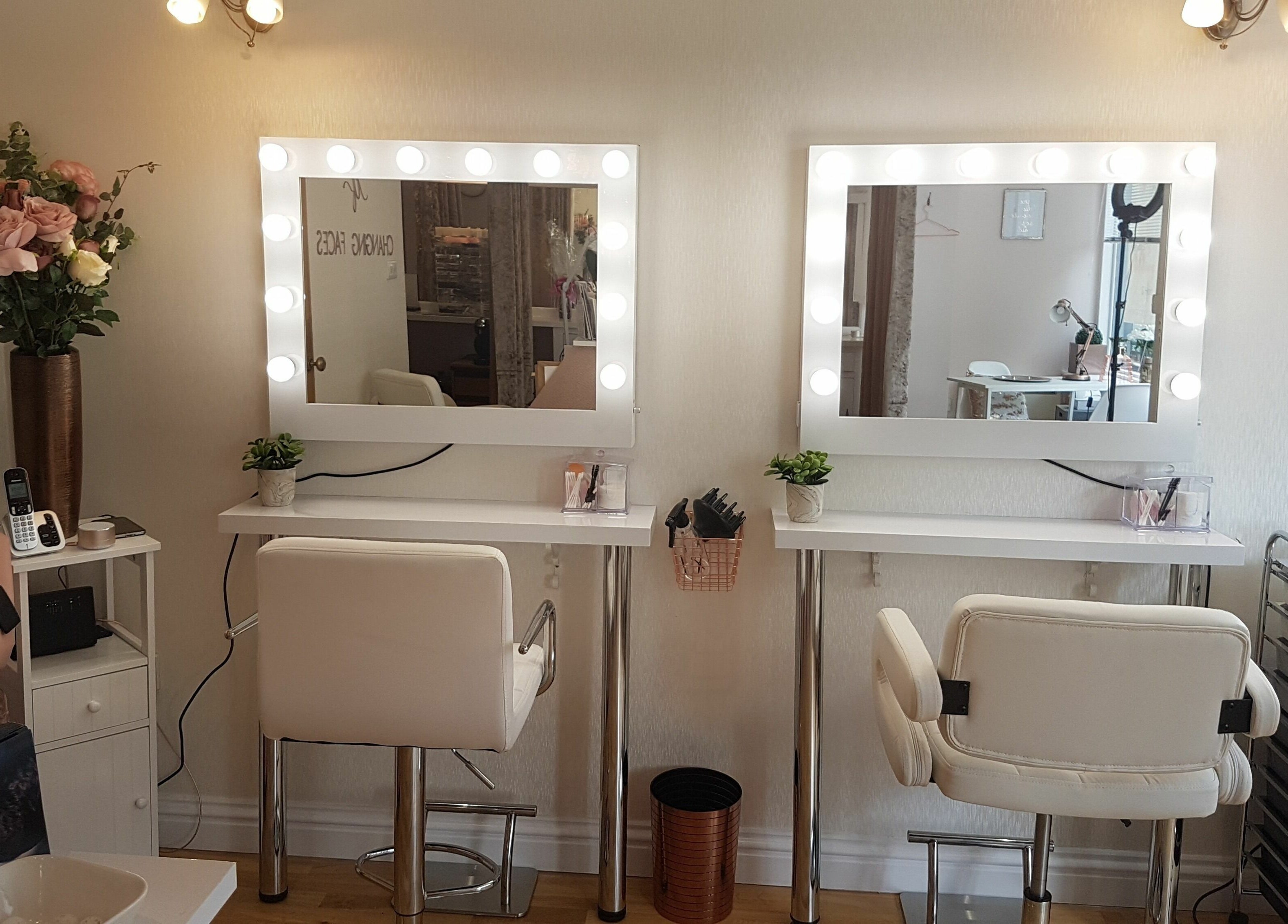 Elegant styling stations at Changing Faces Studio, Exeter, England, GB, with illuminated mirrors and chic decor.