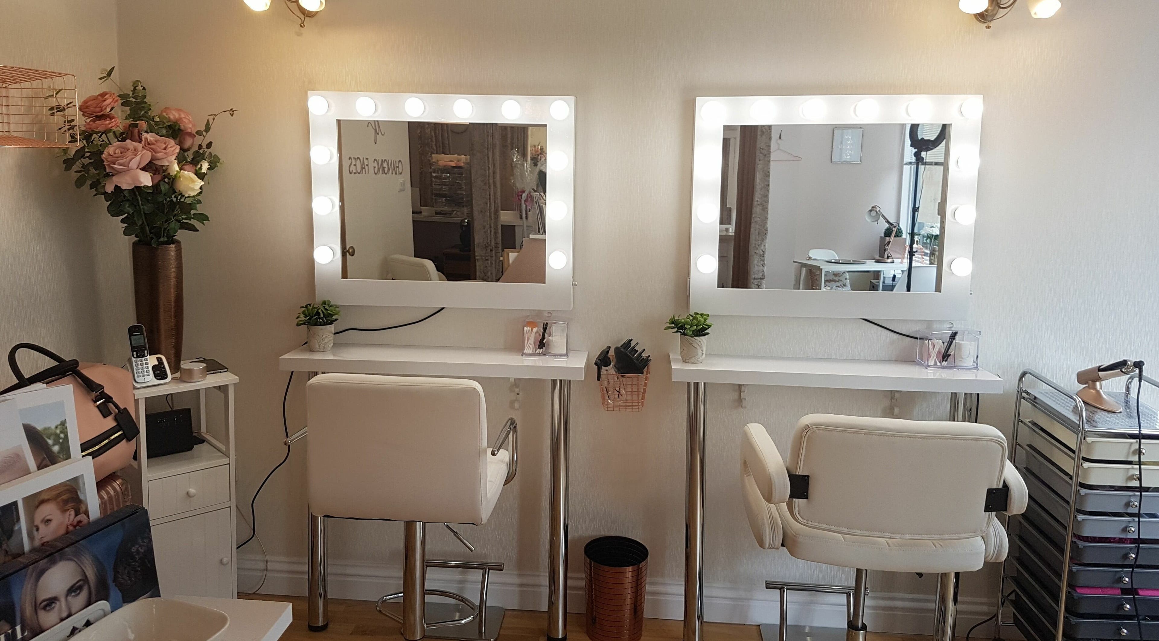 Elegant styling stations at Changing Faces Studio, Exeter, England, GB, with illuminated mirrors and chic decor.