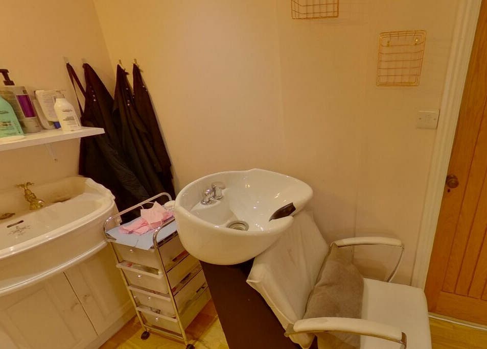 Hair washing station at Changing Faces Studio, Exeter, England, GB, with products and sink.