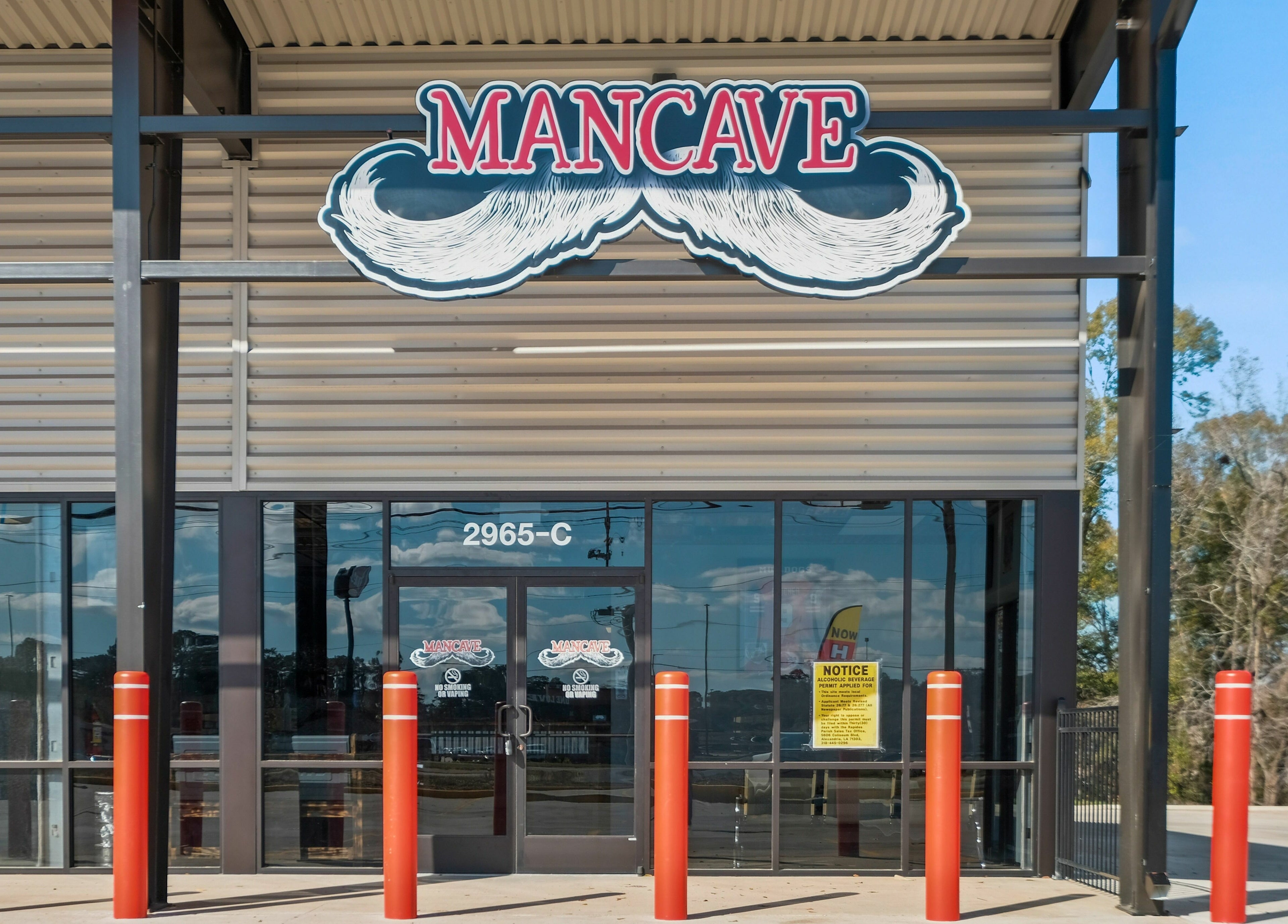 Entrance of Mancave Cenla in Pineville, Louisiana, US, featuring bold signage and modern architecture.