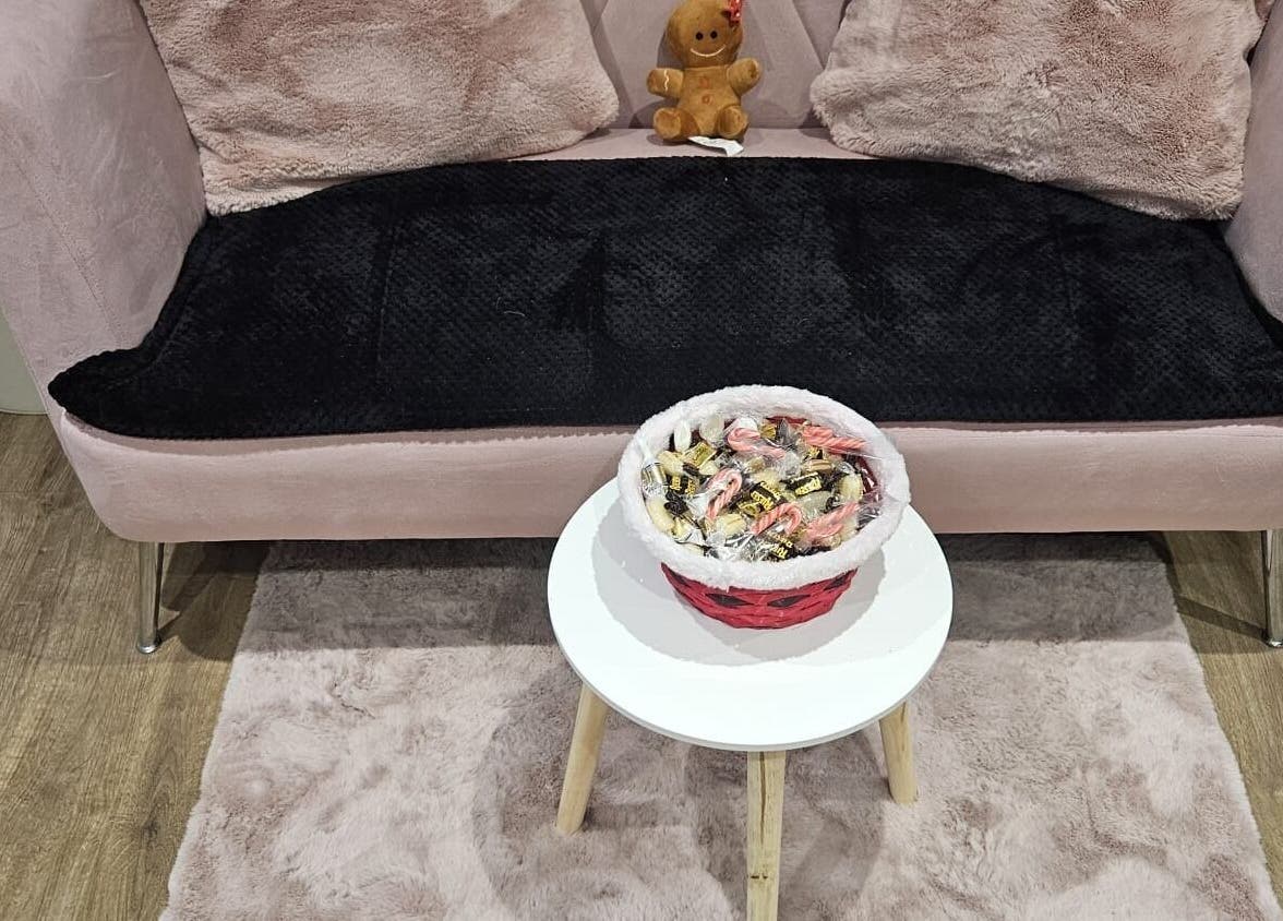 Luxurious seating at Precious Beauty, Hull, England, with plush cushions and a candy-filled basket on a table.