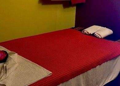 Relaxing massage room at Nakhon Thai Massage, Auckland, Auckland, NZ with a cozy red blanket and fresh towels.