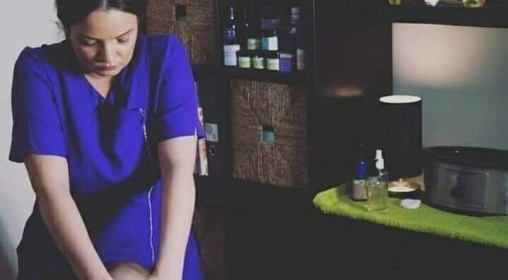 Therapist at Enlighten Therapy in Arnold, England, GB performing a calming massage in a serene setting.