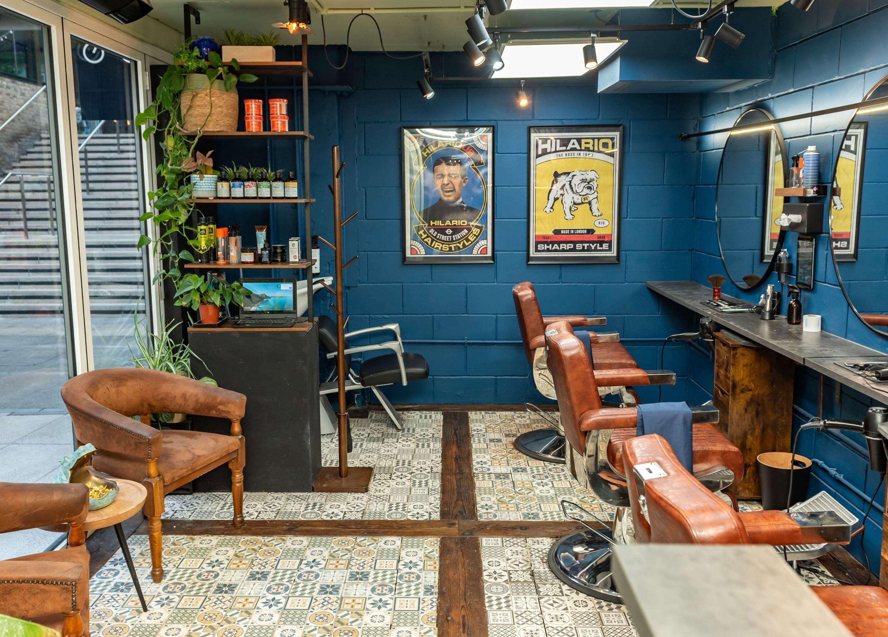 Chic barber shop interior at Hilario, London, England, GB featuring stylish chairs and decor.