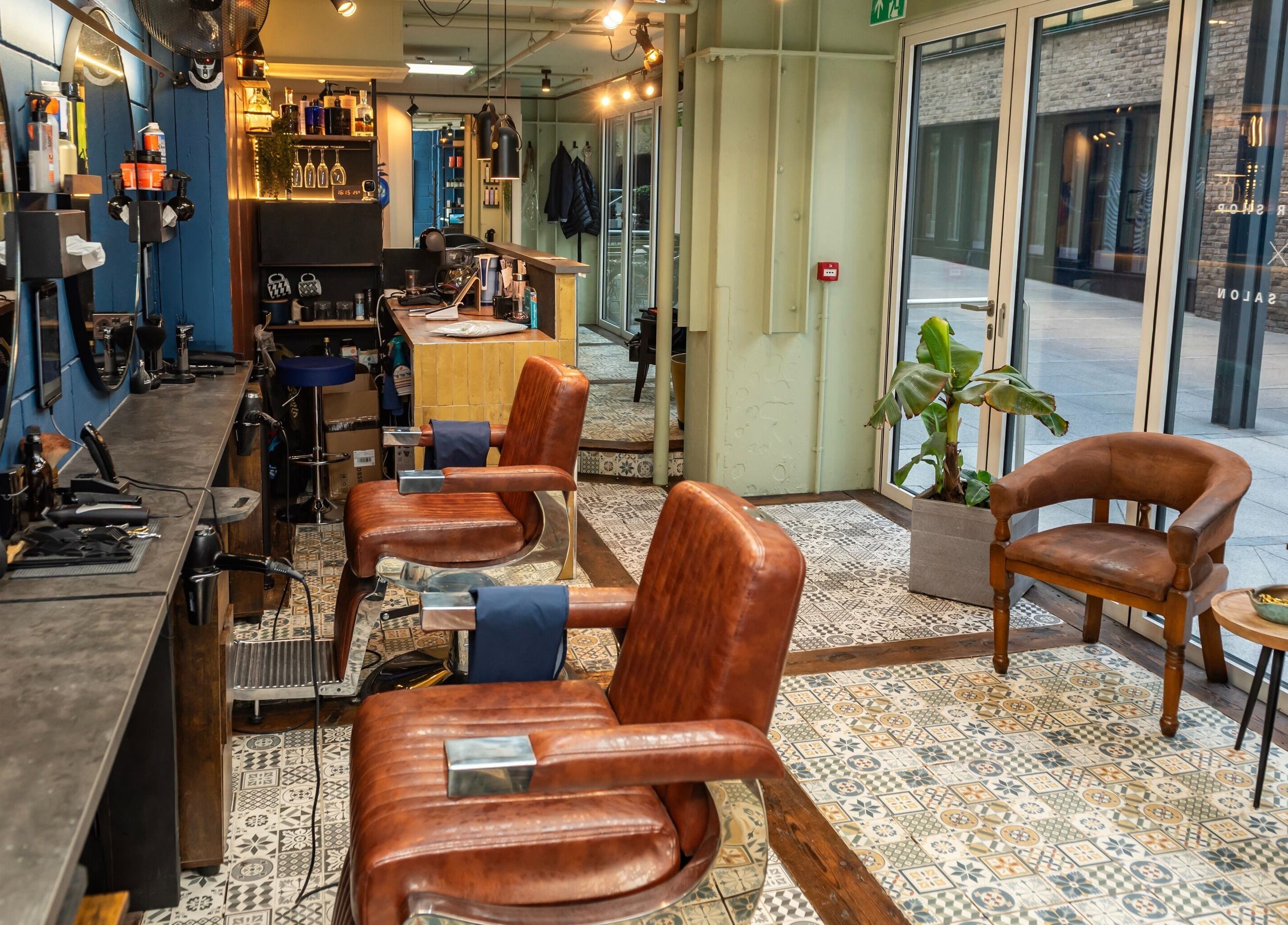 Elegant barber chairs at Hilario, London, England, GB, featuring stylish decor and natural light.