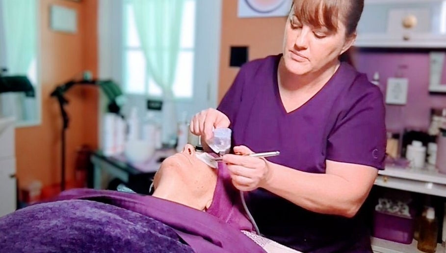 Skincare specialist performing facial at Mud and Lotus Skincare, Burnsville, North Carolina, US.