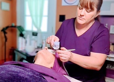 Skincare specialist performing facial at Mud and Lotus Skincare, Burnsville, North Carolina, US.
