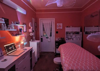Cozy skincare room at Mud and Lotus Skincare, Burnsville, North Carolina, US, with ambient lighting and treatment bed.