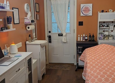 Cozy skincare room at Mud and Lotus Skincare in Burnsville, North Carolina, US, featuring treatment bed and products.