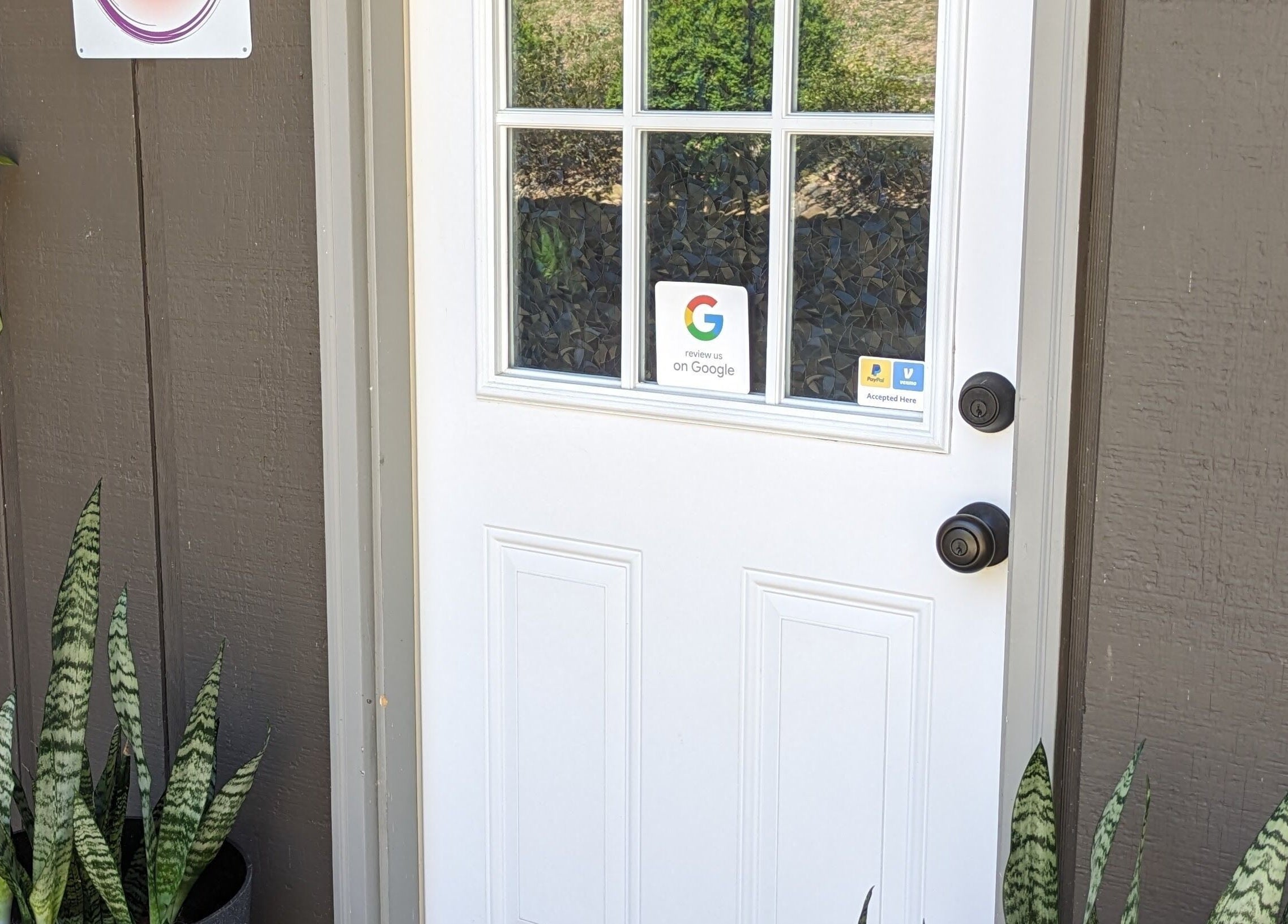 Front door of Mud and Lotus Skincare in Burnsville, North Carolina, US, framed by decorative plants.
