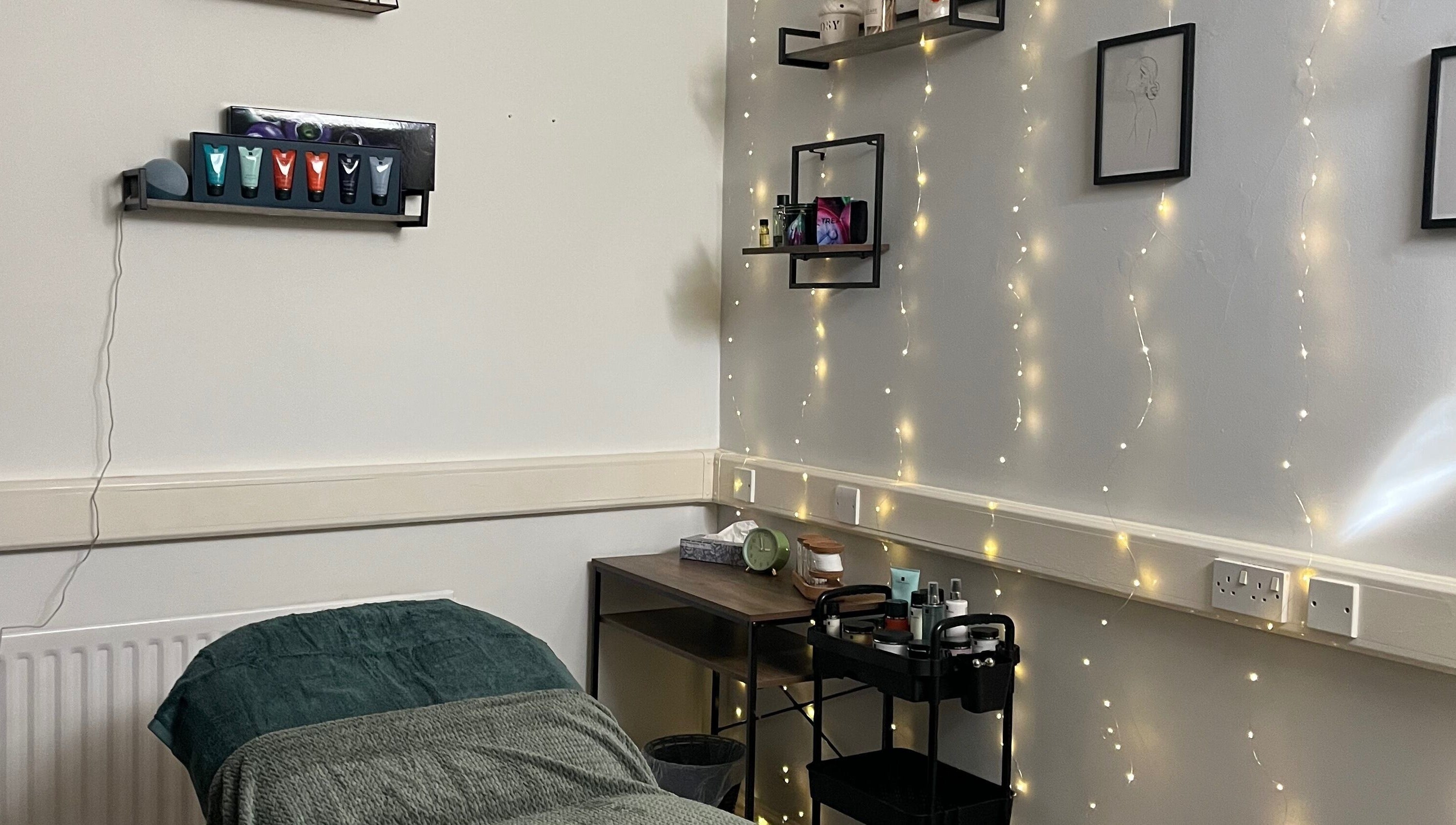 Tranquil treatment room at Jojo May Wellbeing, Redditch, England, GB with soft lighting and skincare essentials.