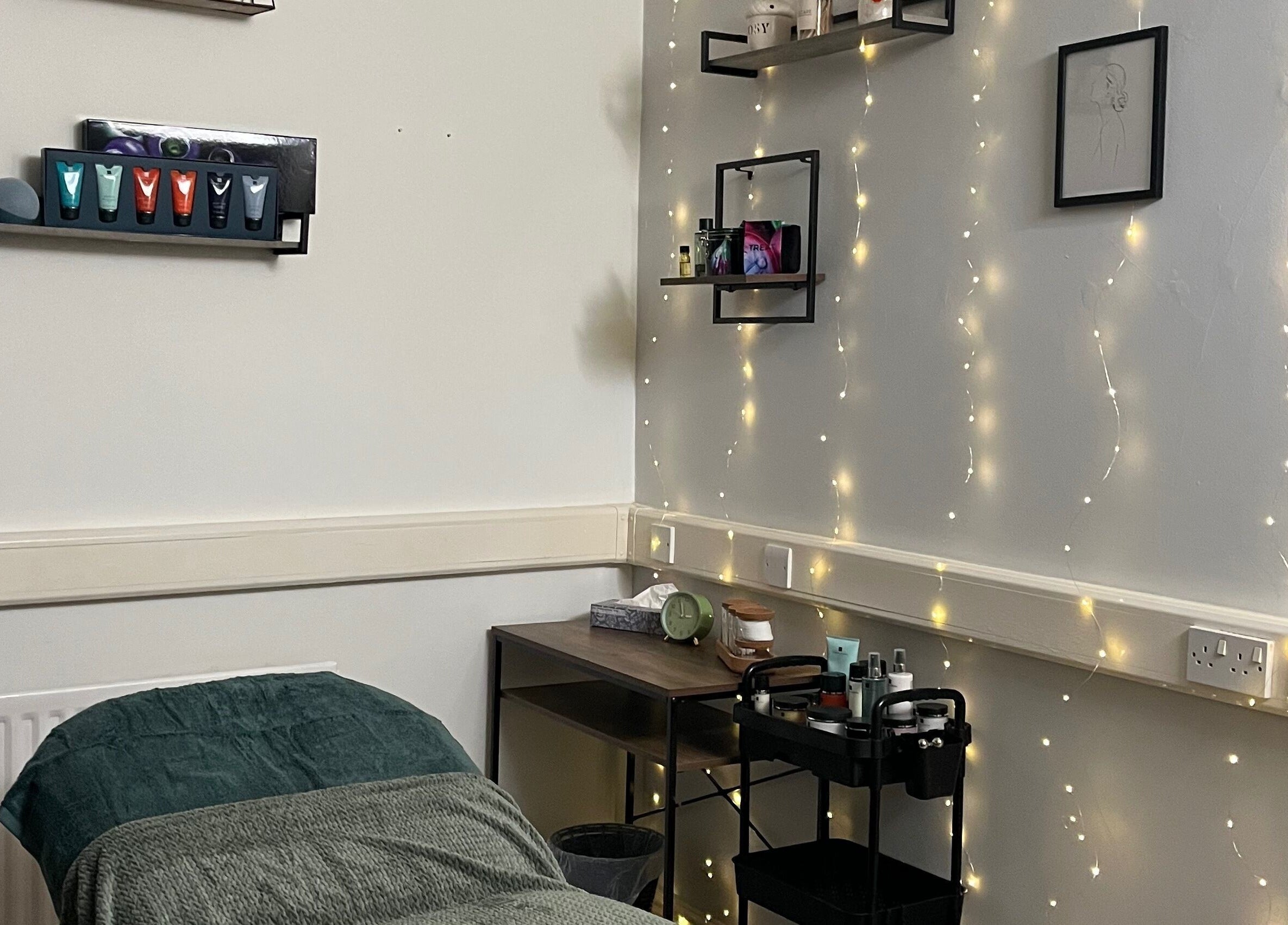 Tranquil treatment room at Jojo May Wellbeing, Redditch, England, GB with soft lighting and skincare essentials.