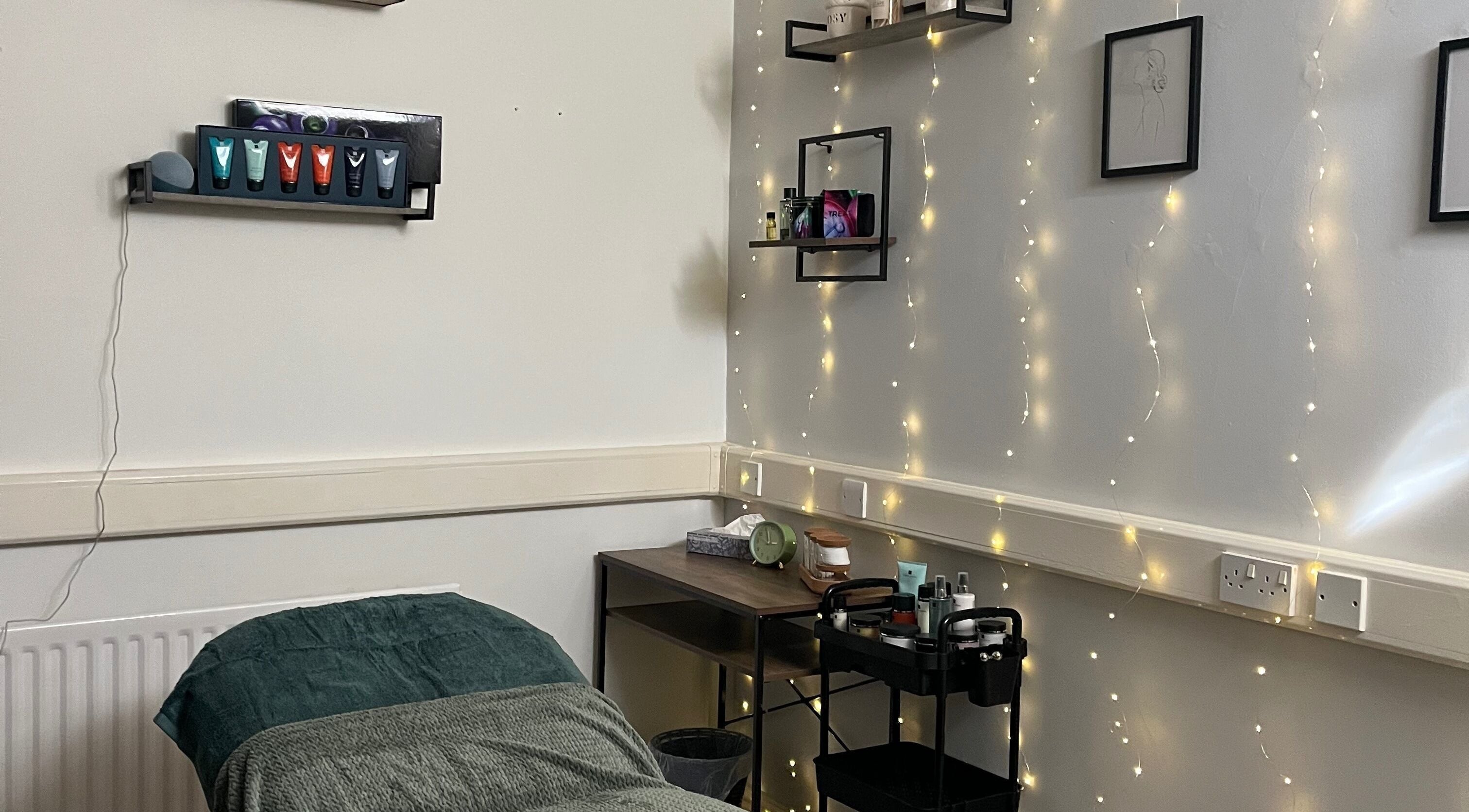 Tranquil treatment room at Jojo May Wellbeing, Redditch, England, GB with soft lighting and skincare essentials.