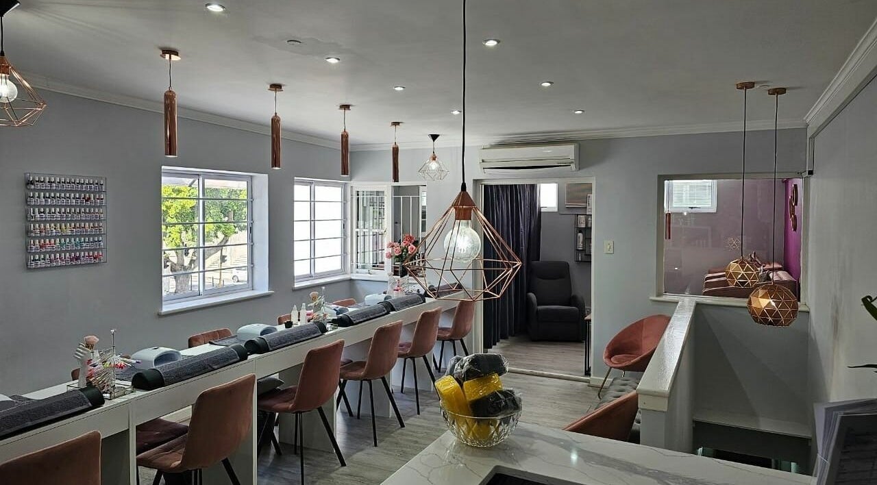Modern and chic interior of Mc Nail and Beauty Salon in Cape Town, Western Cape, ZA with stylish lighting and seating.